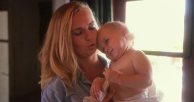 Gülümseyen anne kucağında tatlı huysuz bir bebek