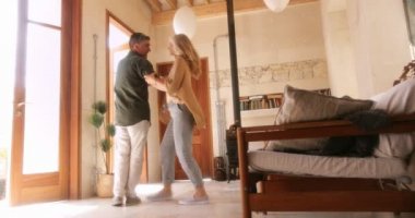 Mutlu kıdemli karı koca evde dans ediyor ve flört ediyor.