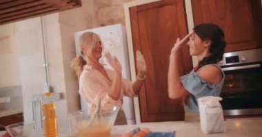 Mutfakta torunumla yemek pişirirken mutlu bir büyükanne beşlik çakıyor.