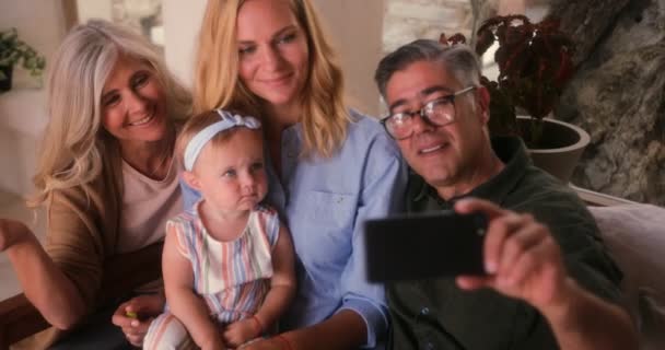 Gelukkig multi-generatie familie met behulp van smartphone en het nemen van selfies thuis — Stockvideo