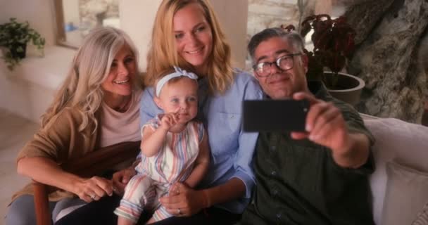 Senior couple with daughter and granddaughter taking selfies at home — Stock Video