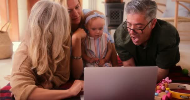 Счастливая семья из трех поколений с маленькой внучкой, которая смотрит мультики на ноутбуке — стоковое видео