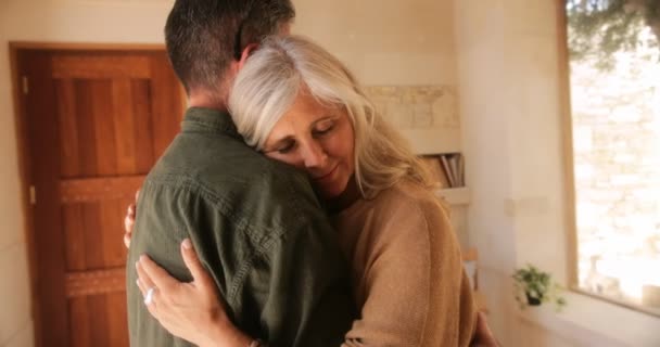 Зрелая женщина расслабляется в объятиях романтических мужей дома — стоковое видео