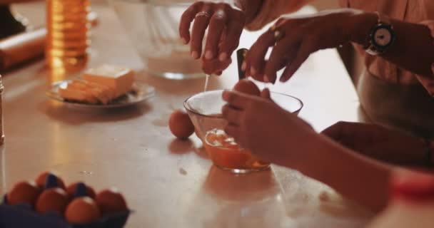 Yetişkin kadın ve kızın pişirmek için yumurta kırdığı yakın plan. — Stok video