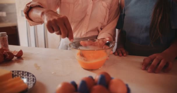 Primer plano de la mujer batiendo huevos en un tazón de vidrio para hornear — Vídeos de Stock