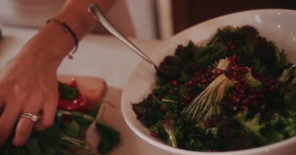 Közelkép egy nőről, aki friss mediterrán salátát készít gránátalmával — Stock videók
