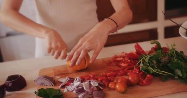 Žena krájí zeleninu a citron na dřevěné řezací desce — Stock video
