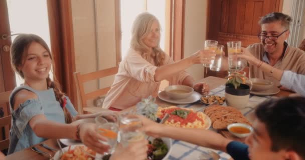 Rodziny wieloetniczne z dziadkami i wnukami jedzącymi lunch w domu — Wideo stockowe