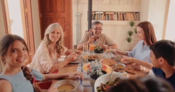 Lycklig familj som äter hälsosam medelhavsmat hemma — Stockvideo