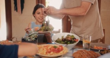 Büyükbabam aile yemeğinde toruna taze Akdeniz salatası ikram ediyor.