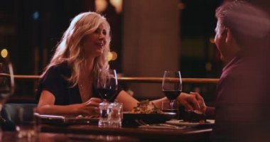 Zarif son sınıf çifti restoranda romantik bir akşam yemeği yerken eğleniyor.