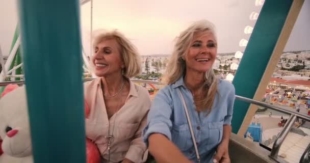 Mulheres maduras felizes se divertindo no passeio de roda gigante — Vídeo de Stock