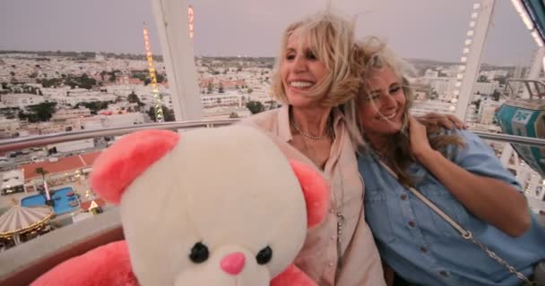 Gli amici maturi si divertono a viaggiare in giro sulla ruota panoramica del carnevale — Video Stock