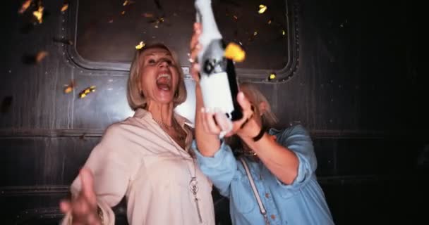 Excited senior friends partying with champagne and confetti — Stock Video