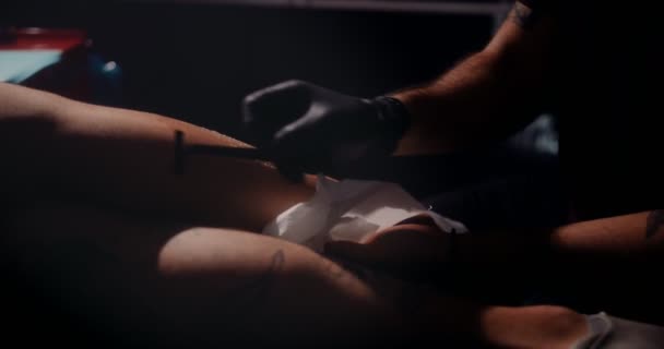 Professionele tattoo artiest scheren en voorbereiden klant voor tattoo werk — Stockvideo