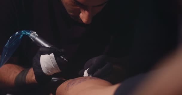 Tatouage maître habile conception de tatouage avec de l'encre sur la jambe des clients — Video