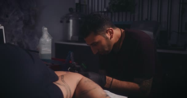 Καλλιτέχνης τατουάζ που εργάζονται σε πελάτες τατουάζ στο επαγγελματικό στούντιο τατουάζ — Αρχείο Βίντεο