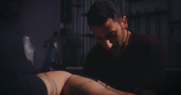 Professional skilled tattoo master making tattoo design on clients skin — Stock Video