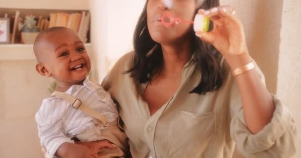 Young happy mother and excited baby boy blowing bubbles — Stock Video