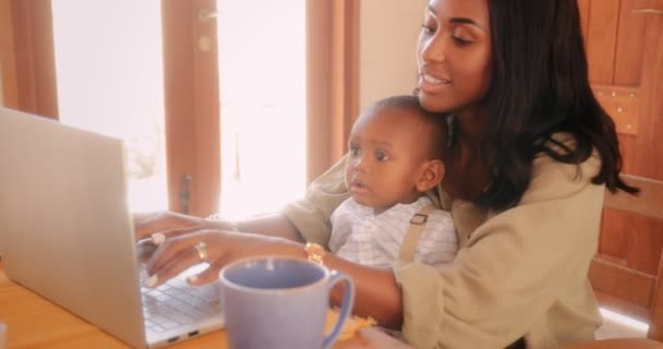 Blogger mother with baby boy working from home on laptop — 图库视频影像