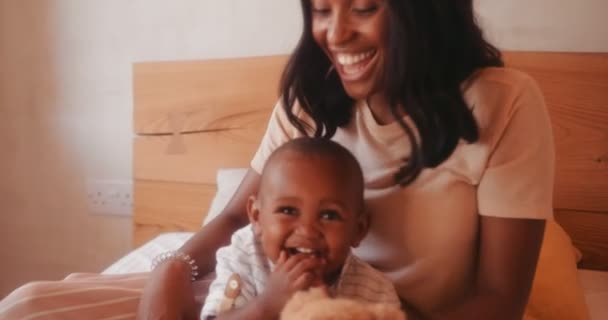 Junge Mutter und kleiner Sohn spielen mit Spielzeug im Bett — Stockvideo