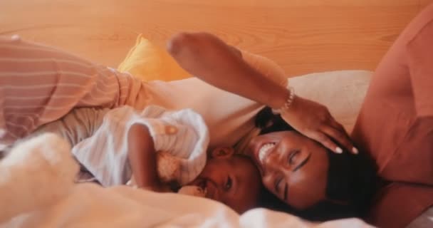Lykkelig mor og liten gutt i pyjamas som leker sammen – stockvideo