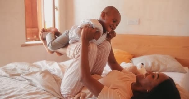 Веселая молодая мама играет с ребенком в спальне — стоковое видео