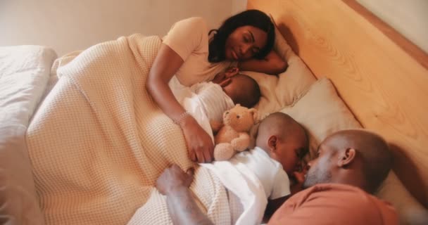 Семья с двумя сыновьями спят вместе в постели — стоковое видео