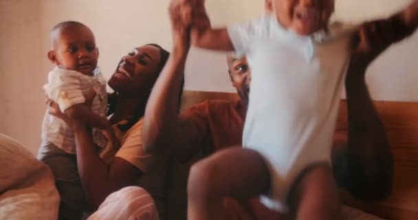 Unga glada föräldrar leker med små barn i sängen — Stockvideo