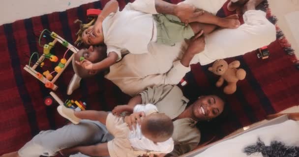 Счастливые мама и папа играют с сыновьями дома — стоковое видео