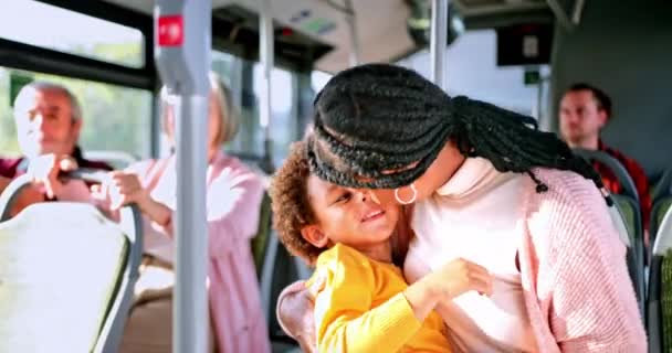 Afro-Amerikaanse moeder zoenen en wrijven neuzen met zoon in bus — Stockvideo