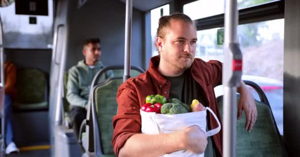 Mann sitzt in Linienbus mit Einkaufstasche — Stockvideo