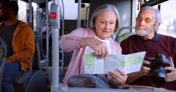 Coppia anziana guardando insieme la mappa che viaggia all'interno del bus — Video Stock
