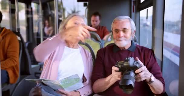 Coppia anziana visita della città e scattare foto con fotocamera all'interno del bus — Video Stock