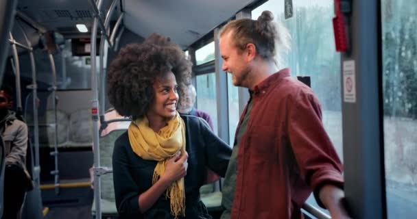 Casal inter-racial rindo segurando uns aos outros dentro do ônibus público — Vídeo de Stock