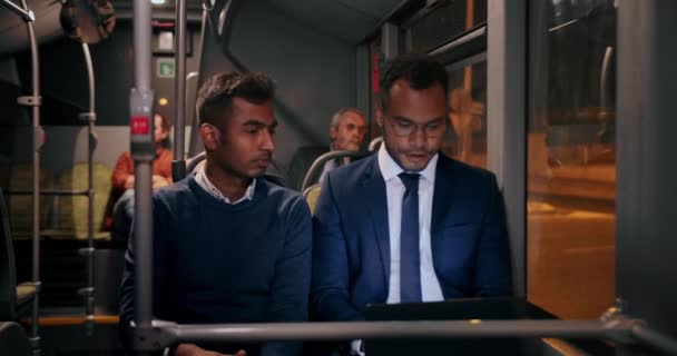 Två affärsman som arbetar på bärbar dator på en buss — Stockvideo