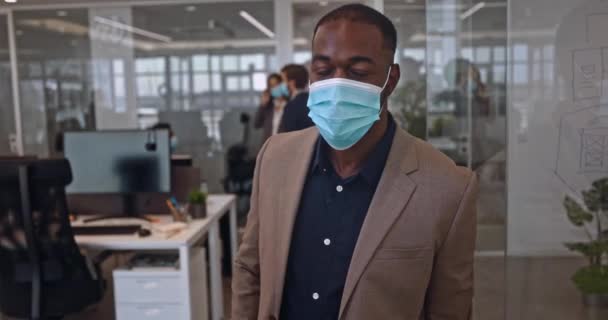 Afroamerykanin biznesmen z covid maska w szklanym nowoczesnym biurze — Wideo stockowe