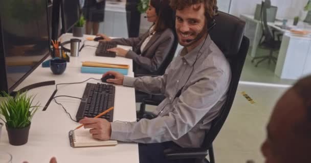 Callcenter-Kollegen mit Headset plaudern im Büro — Stockvideo