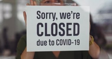 Kadın, Covid-19 salgınından dolayı dükkanı kapatıyor.