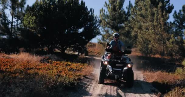 Amigos con cascos montando quads juntos en el bosque — Vídeo de stock