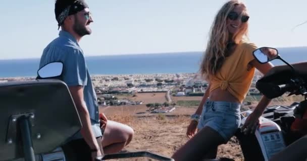 Dos amigos sentados en quads sonriendo y riendo juntos — Vídeos de Stock