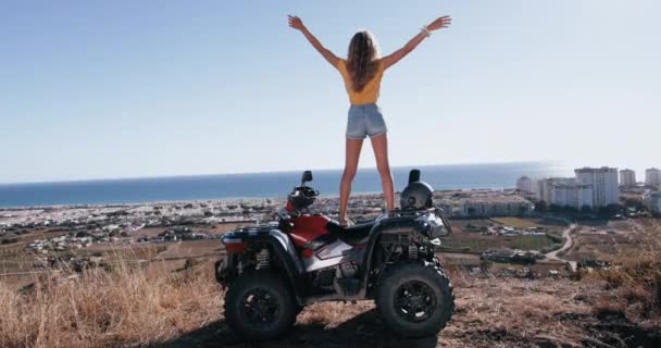 四轮摩托车顶上张开双臂的女人感觉很自由 — 图库视频影像