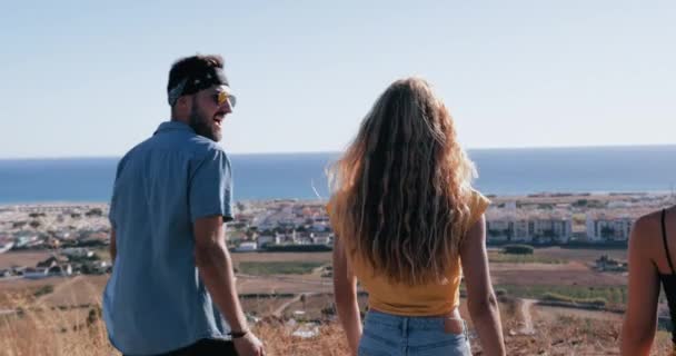 Przyjaciele przytulający się na szczycie klifu z widokiem na morze — Wideo stockowe