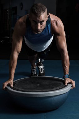 Yapay bacak bacak şınav mı bosu topu içinde jimnastik salonu ile yetişkin kaslı adam 
