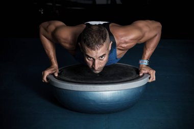 Spor salonunda eğitim ve dört gözle bosu topu Dengeleme şınav emin yetişkin sporcu
