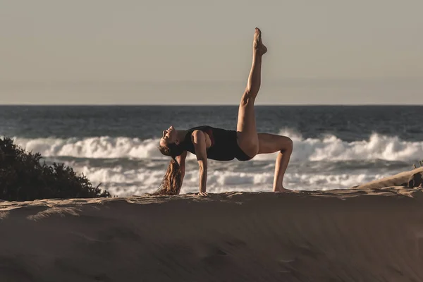 サンディのアーサナでリラックスした女性の側面図海の海岸線上の平和でヨガの練習のビーチします — ストック写真
