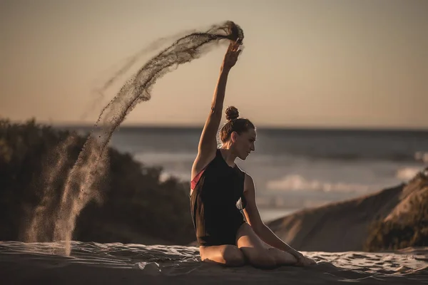 Fit Woman Bodysuit Sitting Beach Shoreline Pouring Heap Sand Making — Stock Photo, Image