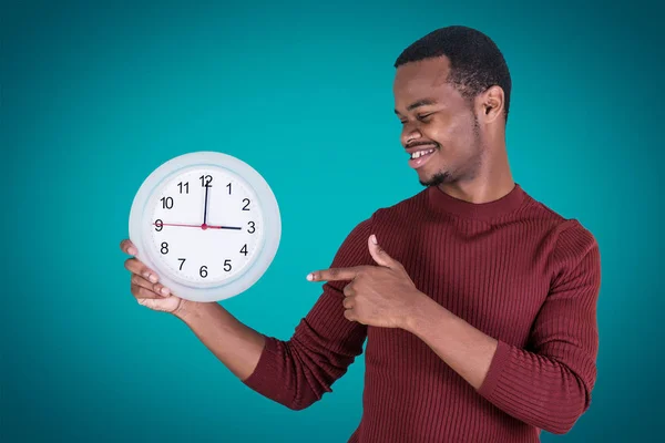 Smiling black man pointing at clock
