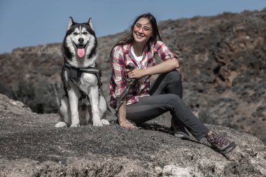 Taşlı tepede oturan komik köpek ile Neşeli kadın