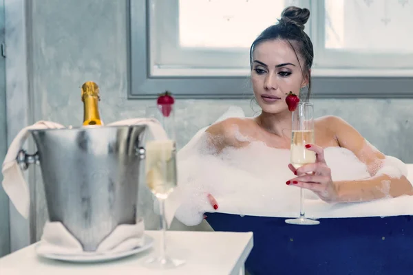 Sensuale donna con champagne fare il bagno a casa — Foto Stock